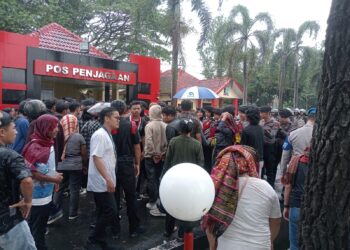 SALING DORONG: Massa Aliansi Masyarakat Gerakan Tutup TPL saling dorong dengan barisan polisi yang berjaga di pintu masuk 2 Mapolda Sumut, Senin (25/3/2024). (Foto Dok/ T77)