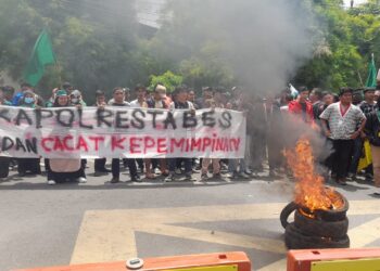 BAKAR BAN: Mahasiswa Cipayung Plus Kota Medan menggelar unras sekaligus membentang spanduk bertuliskan "Kapolrestabes Medan Cacat Kepemimpinan" dan bakar ban di depan Mapolrestabes Jalan HM Said Medan, Senin (25/3/2024).(Foto Dok/ T77)