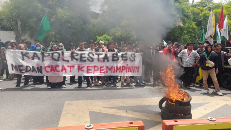 BAKAR BAN: Mahasiswa Cipayung Plus Kota Medan menggelar unras sekaligus membentang spanduk bertuliskan "Kapolrestabes Medan Cacat Kepemimpinan" dan bakar ban di depan Mapolrestabes Jalan HM Said Medan, Senin (25/3/2024).(Foto Dok/ T77)