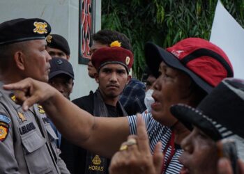 DIHADANG : Massa Aliansi Masyarakat Gerakan Tutup TPL dihadang barisan polisi yang berjaga di pintu masuk 2 Mapolda Sumut, Rabu (27/3/2024). (Foto Dok/ T77)