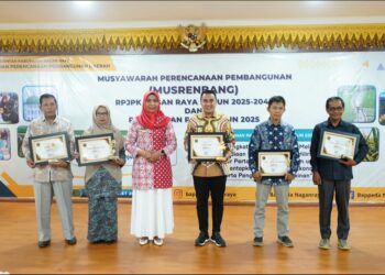 Penyerahan Piagam Penghargaan oleh Penjabat (Pj) Bupati Nagan Raya Fitriany Farhas kepada Kepala Diskominfotik Nila Kasma, usai pembukaan Musyawarah Perencanaan Pembangunan (Musrenbang) RPJPK dan RKPK di Aula Badan Perencanaan Pembangunan Daerah (Bappeda) Kabupaten Nagan Raya, Kamis (28/3/2024).