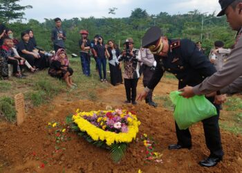 TABUR BUNGA: Kapolsek Delitua, Kompol Dedy Dharma menaburkan bunga ke pusaran Alm. Bripka Mahendra Putra Ginting di Pekuburan Muslim Simalingkar B, Kamis (11/4/2024). (Foto Dok/ Polsek Delta)