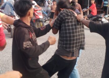 BONYOK: Seorang terduga pelaku pencurian sepeda motor, bonyok diamuk massa di Jalan KL Yos Sudarso, Simpang Kantor, Medan Labuhan, Senin (15/4/2024).(Foto Warga)