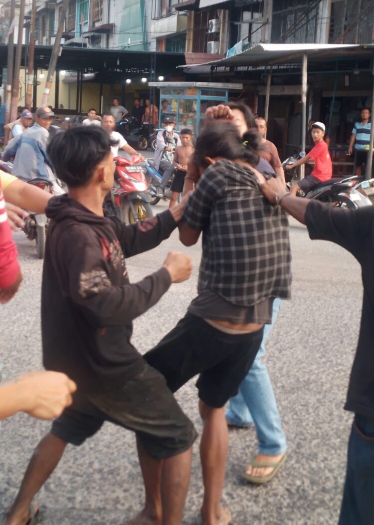 BONYOK: Seorang terduga pelaku pencurian sepeda motor, bonyok diamuk massa di Jalan KL Yos Sudarso, Simpang Kantor, Medan Labuhan, Senin (15/4/2024).(Foto Warga)
