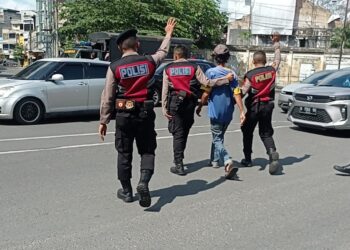 AMANKAN JUKIR: Polrestabes Medan bersama dengan Satgas gabungan mengamankan salah seorang jukir yang terjaring razia, Minggu (21/4/2024).(Foto Dok/Polrestabes)