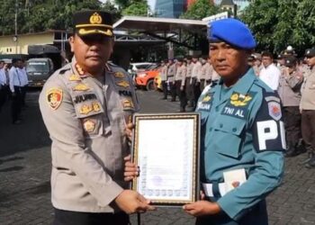 Kapolresta Manado, Kombes Pol Julianto Sirait, memberikan penghargaan kepada Sertu Pom Marijan dari TNI Pomal Lantamal VIII atas dedikasi dan kerja kerasnya dalam membantu penyidik Polresta Manado dalam proses evakuasi tersangka kasus pembunuhan di wilayah hukum Polresta Manado, Senin (22/4/2024).