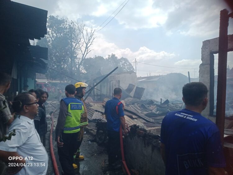 PADAMKAN API: Petugas pemadam kebakaran berusaha memadamkan api dengan menyemprotkan air di rumah permanen Asrama Kodam  I/BB Jalan Sejati Gang Tangsi Kelurahan Sidorame Barat, Kecamatan Medan Perjuangan, Selasa (23/4/2024).(Foto Dok/T77)