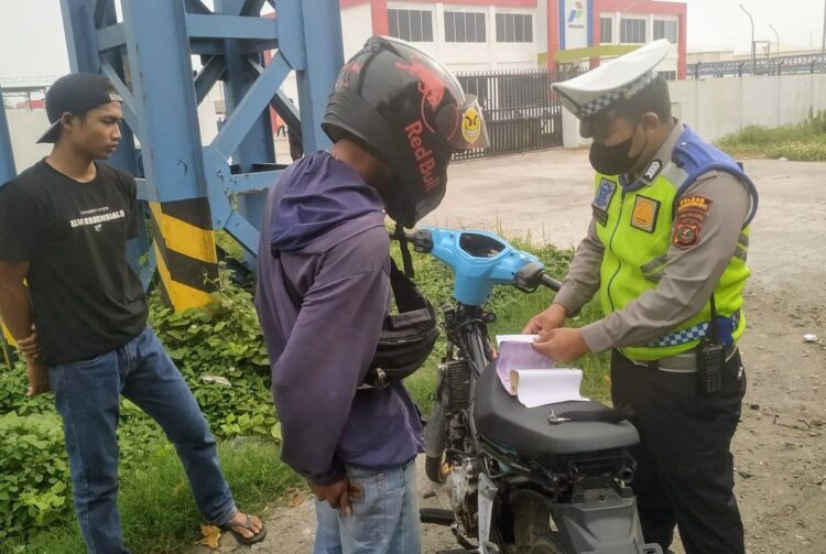 TINDAK: Personel Unit Lantas Polres Pelabuhan Belawan menindak seorang pengendara sepeda motor, yang melakukan pelanggran berlalu lintas, Kamis (2/5/2024).(Foto Dok/Polres Belawan)