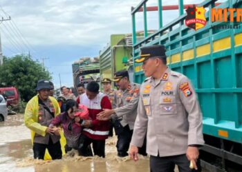 Kapolres Sidrap AKBP Erwin Syah, S.I.K.M.H bersama Wakapolres Kompol Ahmad Rosma, PJU dan Palang Merah Indonesia (PMI) turun pantau situasi banjir dan bantu evakuasi masyarakat yang terdampak di Jalan Poros Sidrap -Wajo, Kecamatan Dua Pitue, Sidrap. Jumat (3/4/2024).