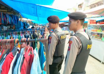 Personil Polsek Pangururan melakukan patroli jalan kaki di luar pasar, memberikan himbauan kepada pembeli yang akan memasuki pasar dan memantau situasi di objek vital yang ada di sekitar pasar seperti kantor bank.