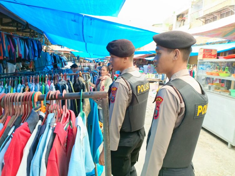 Personil Polsek Pangururan melakukan patroli jalan kaki di luar pasar, memberikan himbauan kepada pembeli yang akan memasuki pasar dan memantau situasi di objek vital yang ada di sekitar pasar seperti kantor bank.