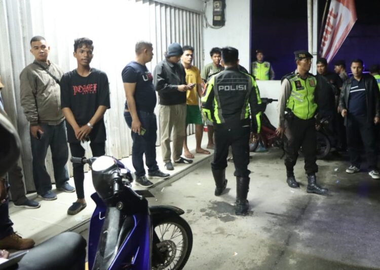 PERIKSA : Personel gabungan Polres Sergai memeriksa pemuda yang sedang berkumpul-kumpul saat menggelar patroli skala besar, Rabu (22/5/2024) malam. (Foto Dok/Humas Polres)