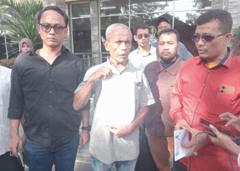 MELAPOR: Amran Toni didampingi penasehat hukumnya, Eka Putra Zakran, SH, MH melaporkan adiknya sekeluarga yang menjadi korban penculikan ke SPKT Mapolda Sumut, Senin (10/6). (Foto Dok/ T77)