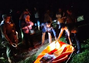 RS = Resoliana Boru Sinaga - EVAKUASI : Personel Polsek Kotarih dibantu warga mengevaksuasi mayat perempuan yang ditemukan di aliran Sungai Buaya, Rabu (26/6/2024) dini hari. (Foto Dok/Polsek Kotarih)