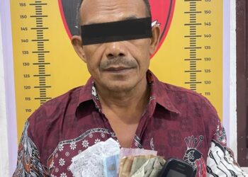 DIAMANKAN : M (52), terduga pelaku perjudian tebak angka jenis kim berikut barang bukti, diamankan di Satreskrim Polres Sergai. (Foto Dok/Humas Polres)