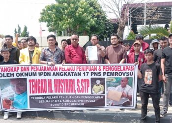 TMH: Tengku Muhammad Husyairi - SAMPAIKAN TUNTUTAN: Harmudia Syahputra didampingi pengacaranya Henry Pakpahan, SH dan Erwin Purba, SH bersama puluhan mahasiswa yang tergabung dalam Forum Diskusi Mahasiswa menyampaikan tuntutan saat melakukan aksi demo di Mapolda Sumut, Selasa (2/7/2024). (Foto: Dok/ T77)