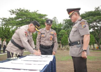 PIMPIN ; Kapolres Sergai, AKBP.Jhon Hery Rakutta Sitepu menandatangani berita acara saat memimpin Sertijab 5 PJU dan 3 Kapolsek di jajaran Polres Sergai, Jumat (12/7/2024). (Foto Dok/ Polres)