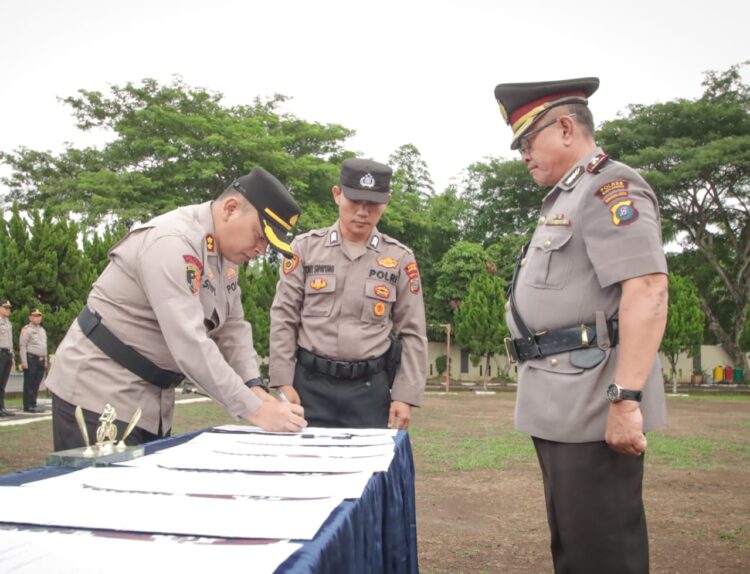 PIMPIN ; Kapolres Sergai, AKBP.Jhon Hery Rakutta Sitepu menandatangani berita acara saat memimpin Sertijab 5 PJU dan 3 Kapolsek di jajaran Polres Sergai, Jumat (12/7/2024). (Foto Dok/ Polres)