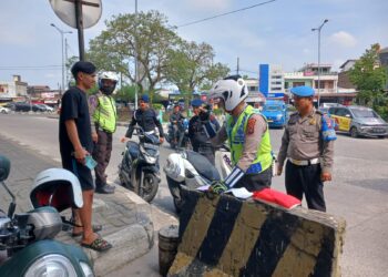 TILANG: Polisi menilang pengendara sepeda motor yang tidak pakai helm pada Ops Patuh Toba 2024 di Bawah Fly Over Amplas, Selasa (16/7/2024). (Foto Dok/ Polda Sumut)