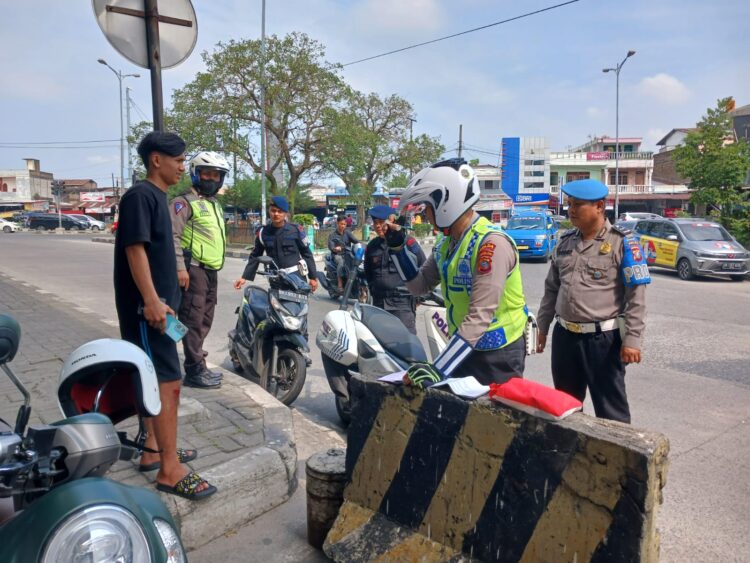 TILANG: Polisi menilang pengendara sepeda motor yang tidak pakai helm pada Ops Patuh Toba 2024 di Bawah Fly Over Amplas, Selasa (16/7/2024). (Foto Dok/ Polda Sumut)