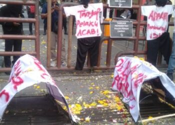 BAWA KERANDA: Puluhan pendemo membawa replika keranda di depan Mapolda Sumut, Kamis (25/7/2024). (Foto: Dok/ T77)