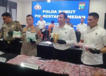TUNJUKKAN BARANG BUKTI: Kapolrestabes Medan Kombes Pol Jhon Sahala Marbun didampingi Kasat Narkoba Kompol Adrian Rizky Lubis menunjukkan barang bukti narkoba jenis sabu dan pil ekstasi yang disita dari tersangka F, di Mapolrestabes, Selasa (30/7/2024).(Foto Dok/ Polrestabes)