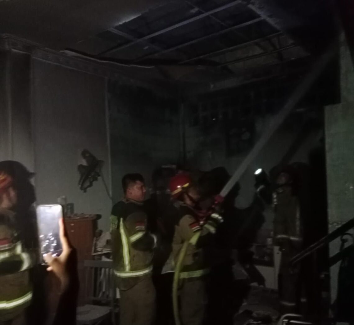 TEWAS TERPANGGANG: Petugas pemadam kebakaran menyemprotkan air ke lokasi rumah yang terbakar di Jalan Pinang Baris II Gang Basket, Kecamatan Medan Sunggal yang mengakibatkan seorang pria lansia yang juga pemilik rumah, Kie Keng Hung tewas terpanggang serta anaknya, Wirabuana mengalami luka bakar, Kamis (22/8/2024).(Foto Dok/Warga)