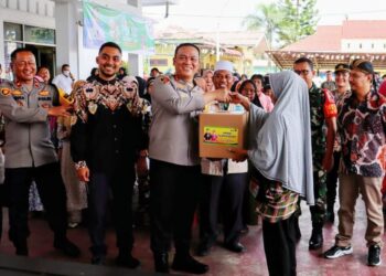 BANTUAN: Kapolres Pelabuhan Belawan menyerahkan bantuan sembako kepada salah seorang warga dalam kegiatan Jumat Curhat dan Jumat Berkah di Kantor Camat Belawan, Jumat (6/9/2024).(Foto Dok/Polres Belawan)