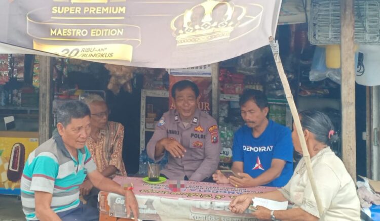 Aiptu H Swandi Sinaga dari Polsek Palipi mengunjungi warung Ibu Boru Sitohang di Desa Huta Dame untuk memberikan himbauan berpolitik sehat.