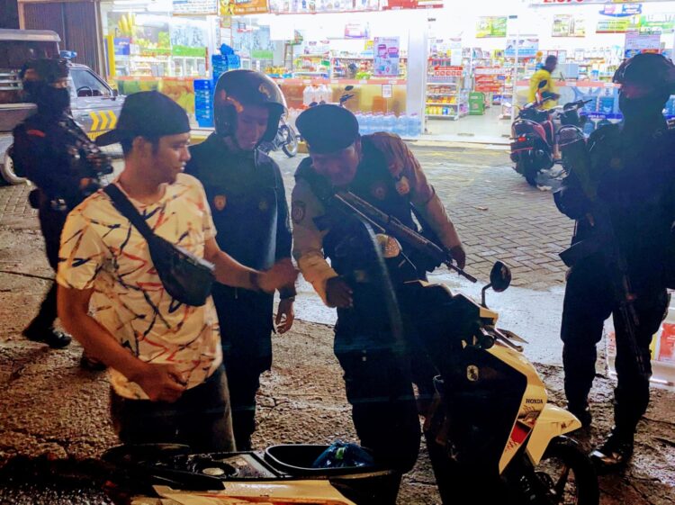 PERIKSA: Petugas Polres Pelabuhan Belawan melakukan pemeriksaan terhadap salah seorang pengendara sepeda motor, dalam kegiatan Patroli Gabungan cegah tindak kejahatan jalanan, Kamis dini hari (12/9/2024).(Foto Dok/Polres Belawan)
