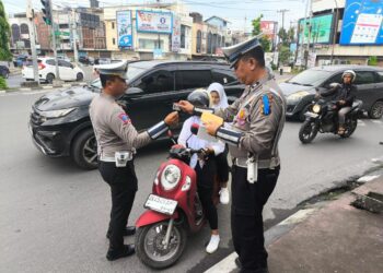 TILANG: Personel Polisi menilang pengendara yang tidak memakai helm pada Operasi Zebra Toba 2024. (Foto Dok/ Polda Sumut).