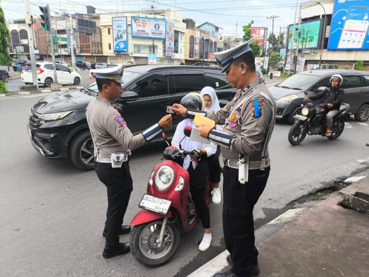 TILANG: Personel Polisi menilang pengendara yang tidak memakai helm pada Operasi Zebra Toba 2024. (Foto Dok/ Polda Sumut).