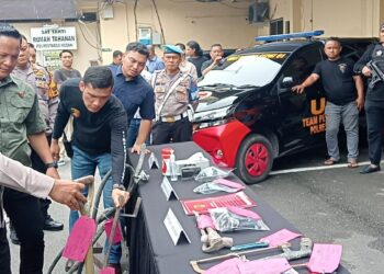 PERLIHATKAN BARANG BUKTI: Kapolrestabes Medan Kombes Pol Gidion Arif Setyawan didampingi Kasat Reskrim Kompol Jama Kita Purba memperlihatkan barang bukti yang disita dari para pelaku kejahatan, di Mapolrestabes, Jumat (18/10/2024).(Foto Dok/ Polrestabes)