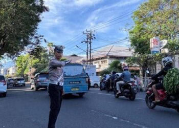 Personel Satlantas Polresta Manado melakukan pengaturan lalu lintas pada pagi hari, Senin (11/11/2024). Pengaturan ini dilakukan di sejumlah titik rawan kemacetan, khususnya di sekitar kawasan perkantoran dan persimpangan utama di Kota Manado.