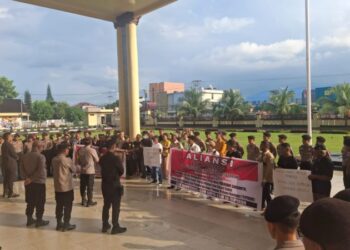 Polsek Sario melakukan pengamanan terhadap aksi damai yang digelar oleh Aliansi LSM-Ormas Gerakan Rakyat Bersatu Anti Korupsi (GEBRAK) Sulawesi Utara di depan Mapolda Sulut, Jalan Bethesda, Kecamatan Sario, Kota Manado. Aksi ini diikuti sekitar 30 peserta yang datang menggunakan tiga unit kendaraan roda empat, Pada Rabu, 13 November 2024, pukul 15.35 WITA.