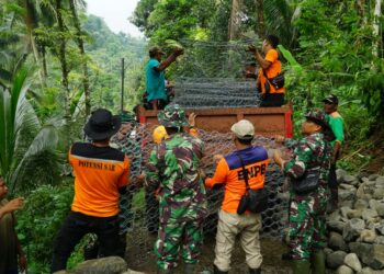 Kerja bakti bersama masyarakat, salah satunya dengan mengumpulkan material batu untuk dimasukkan dalam bronjong untuk membuat tanggul mencegah longsor susulan terjadi sekaligus sebagai jalan darurat agar akses jalan dapat dilewati kembali oleh masyarakat sehingga akses ekonomi, pendidikan dan Pilkada nantinya tidak terkendala
