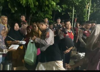 BAGI SEMBAKO: Personil Polda Sumut membagi sembako kepada warga terdampak banjir di Marindal, Rabu (27/11/2024) malam. (Foto Dok/ Polda Sumut)