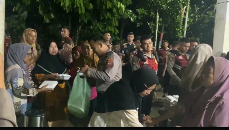 BAGI SEMBAKO: Personil Polda Sumut membagi sembako kepada warga terdampak banjir di Marindal, Rabu (27/11/2024) malam. (Foto Dok/ Polda Sumut)