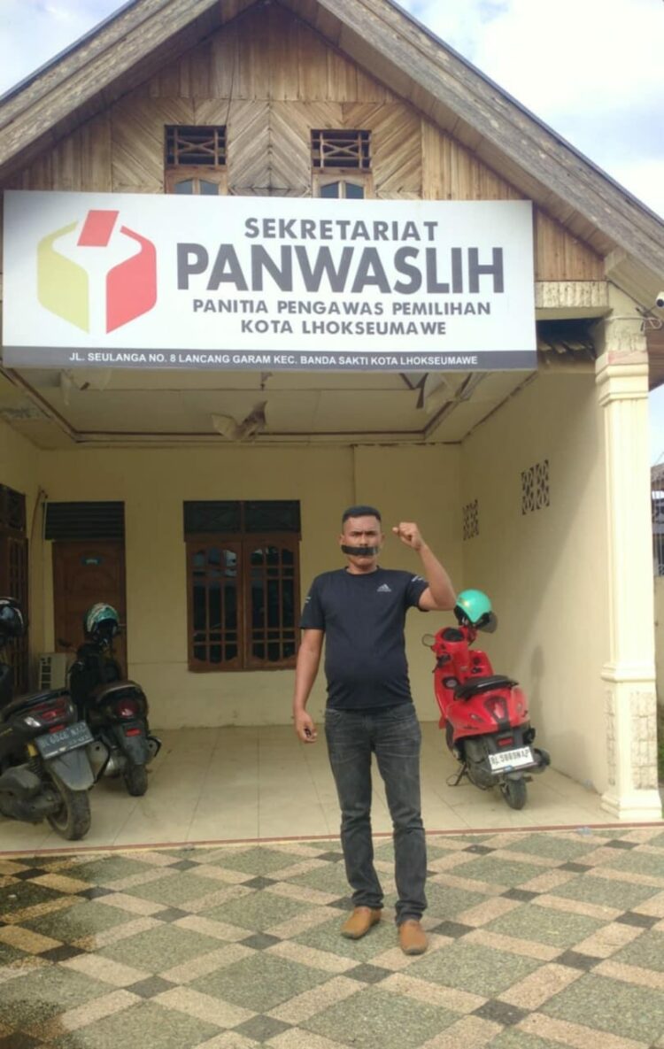 Ridwan, seorang warga kota lhokseumawe melakukan aksi tunggal menutup mulut menggunakan plaster, sebagai bentuk protes terhadap sikap pengawas pemilihan (Panwaslih) setempat. Aksi tersebut berlangsung di depan kantor Pengawas pemilihan (Panwaslih) Kota Lhokseumawe,(Selasa 03/12/2024).