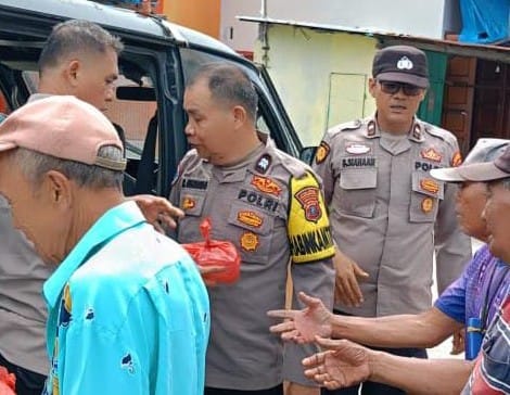 BAGI NASI BUNGKUS: Personel Polsek Belawan membagikan nasi bungkus kepada warga kurang mampu di kawasan Kota Pelabuhan Belawan, Jumat (13/12/2024).(Foto dok/Polres Belawan)
