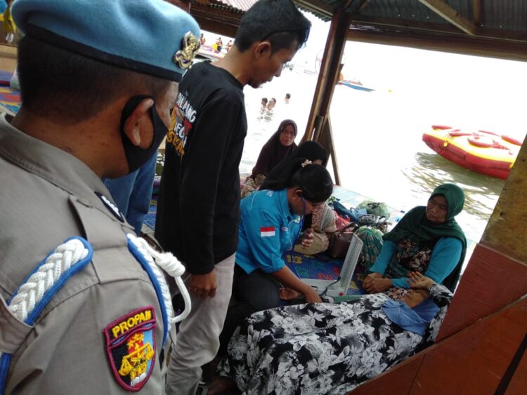 Dalam patroli jalan kaki yang dilakukan di sepanjang Pantai Pasir Putih Parbaba, Kecamatan Pangururan, Kabupaten Samosir, personel pos berhasil memberikan pertolongan kepada seorang wisatawan yang mendadak sakit.