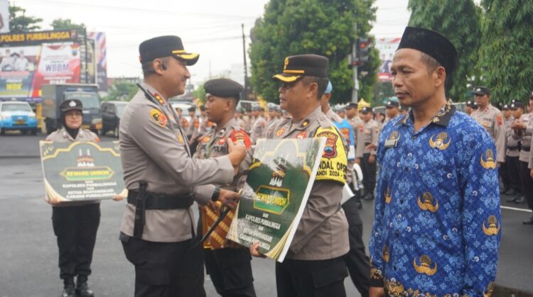 Kapolres Purbalingga AKBP Rosyid Hartanto memberikan hadiah umrah untuk personel dan masyarakat berprestasi. Hadiah tersebut diberikan usai upacara laporan kenaikan pangkat di Halaman Mapolres Purbalingga, Senin (2/12/2024) pagi.