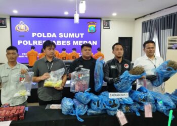 TUNJUKKAN BARANG BUKTI: Wakasat Narkoba Polrestabes Medan, AKP Arham Gusdiar kepada menunjukkan barang bukti ganja yang disita dari 5 tersangka, di Mapolrestabes, Kamis (16/1/2025).(Foto Dok/ Poltestabes)