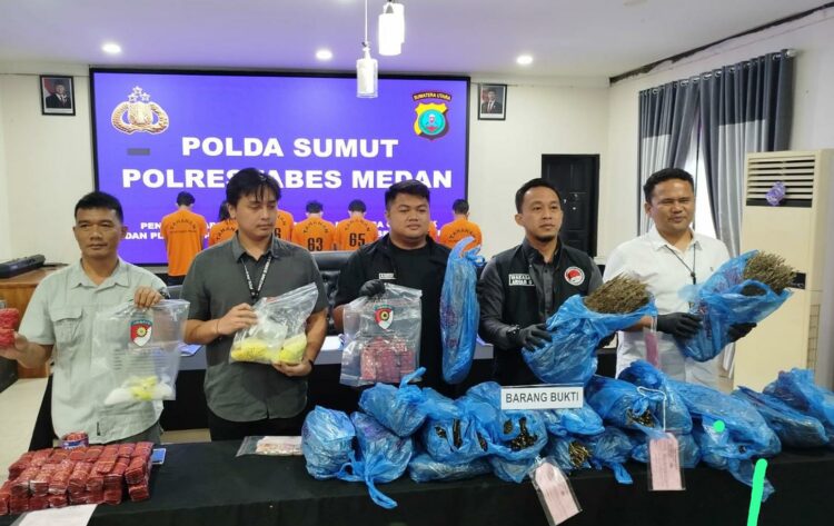 TUNJUKKAN BARANG BUKTI: Wakasat Narkoba Polrestabes Medan, AKP Arham Gusdiar kepada menunjukkan barang bukti ganja yang disita dari 5 tersangka, di Mapolrestabes, Kamis (16/1/2025).(Foto Dok/ Poltestabes)