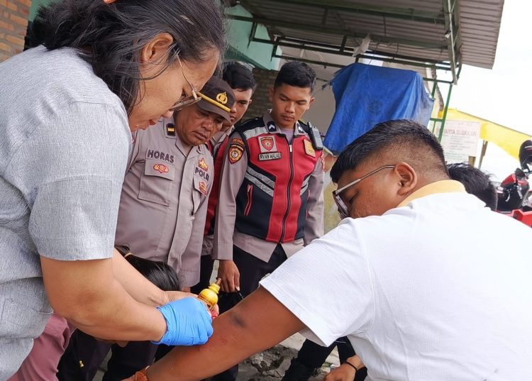 Personel Pos Pelayanan Simpang 4 HKBP Bolon Operasi Ketupat Toba 2025 Polres Samosir memberikan pertolongan cepat kepada dua orang pengendara sepeda motor yang mengalami kecelakaan tunggal di tikungan simpang empat Jalan Gereja Pangururan, Sabtu (5/4/2025) sekitar pukul 12.40 WIB.