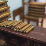 https://www.pexels.com/id-id/foto/produksi-cerutu-mentah-di-atas-meja-kayu-di-kain-3975055/