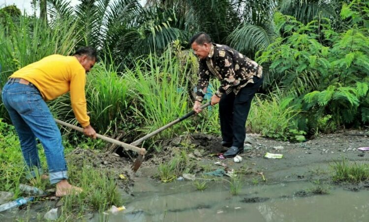 Melintasi Jalan Tergenang Air, Bupati Simalungun Buat Aliran Air