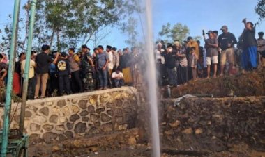 Warga menyaksikan semburan air setinggi belasan meter di Kabupaten Sampang