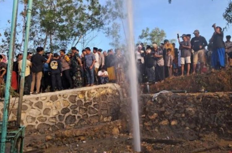 Warga menyaksikan semburan air setinggi belasan meter di Kabupaten Sampang