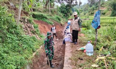 Babinsa Koramil 2207/Jampangtengah Laksanakan Bhakti Pembersihan Irigasi Persawahan